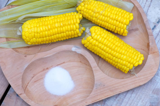 Des grains de maïs frais éclatent de couleur sur une table, représentant la diversité et la polyvalence de ce légume dans la cuisine.